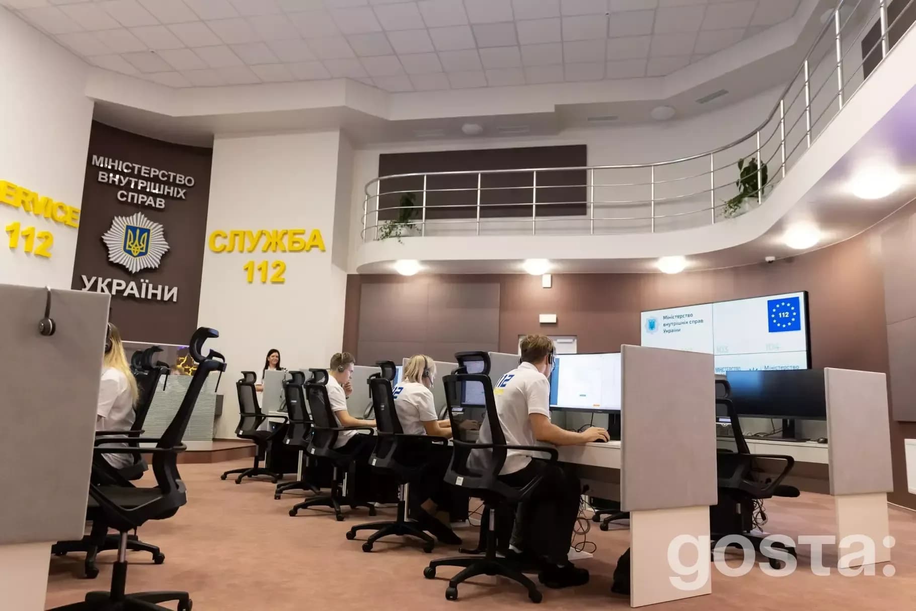 Співробітники Служби 112 України працюють у сучасному операційному центрі з великими моніторами та панелями.