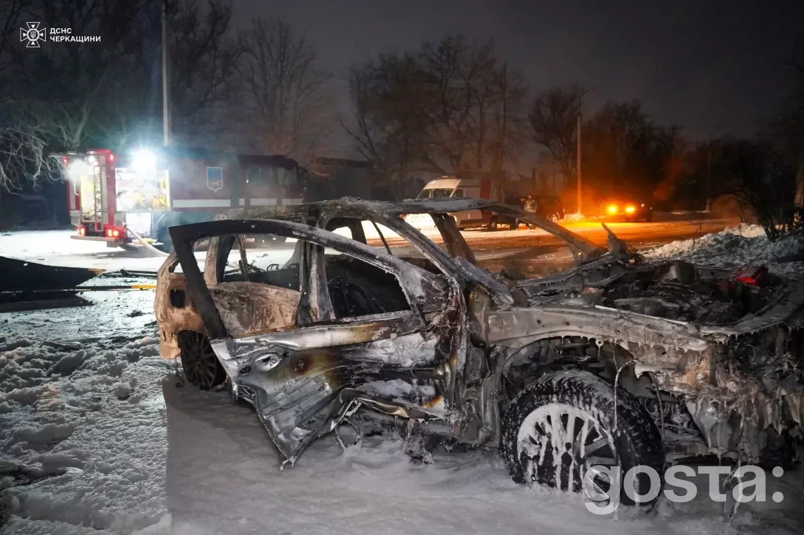 Обгорілий автомобіль після обстрілу в Черкасах, зима 2026 року, пошкоджені інші транспортні засоби, працюють рятувальник