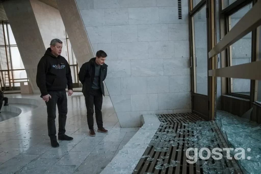 На зображенні два чоловіка оглядають розбиті вікна в музеї після ракетного удару по Україні 3 лютого.