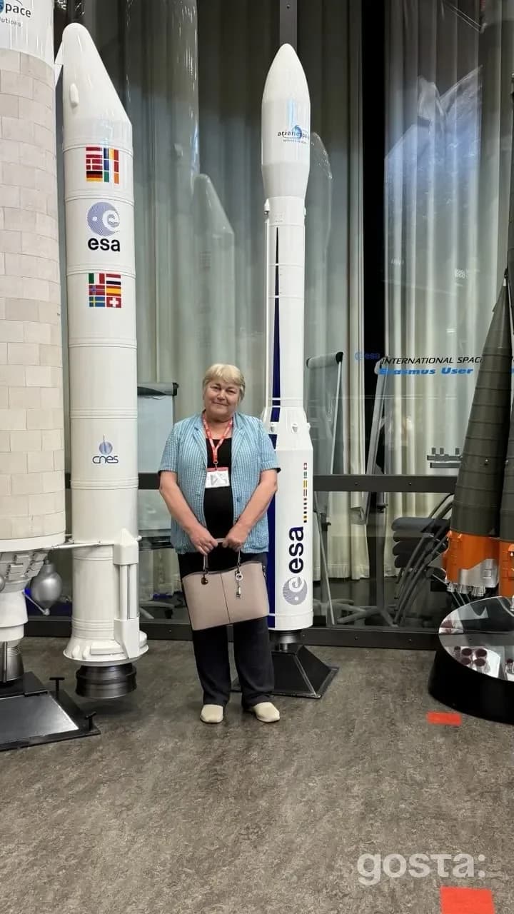 Науковиця Даша Добричева на фоні ракет ESA та CNES на виставці про нові галактики з полярними кільцями.