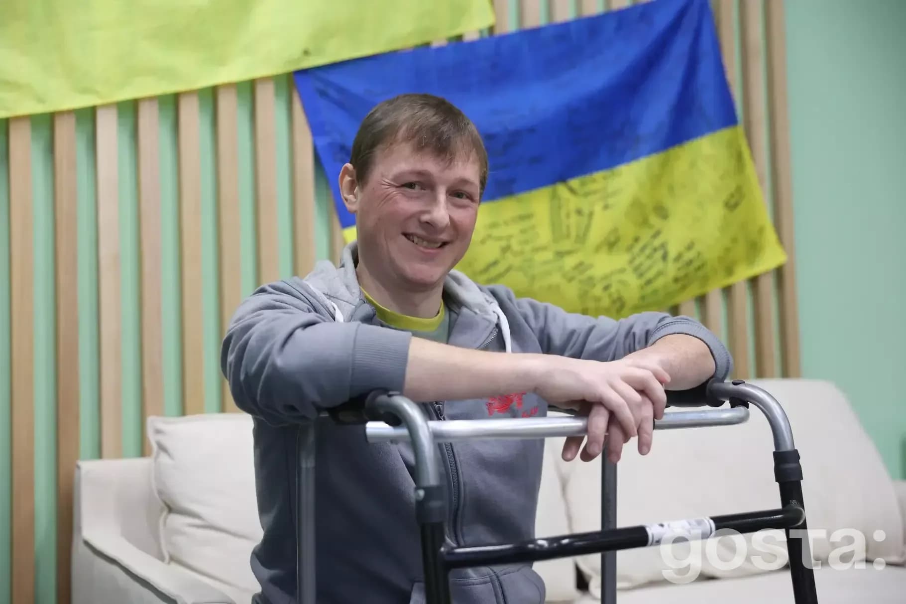 Солдат батальйону «Спартан» Мусінзов Володимир, реабілітація, усмішка на фоні українських прапорів.