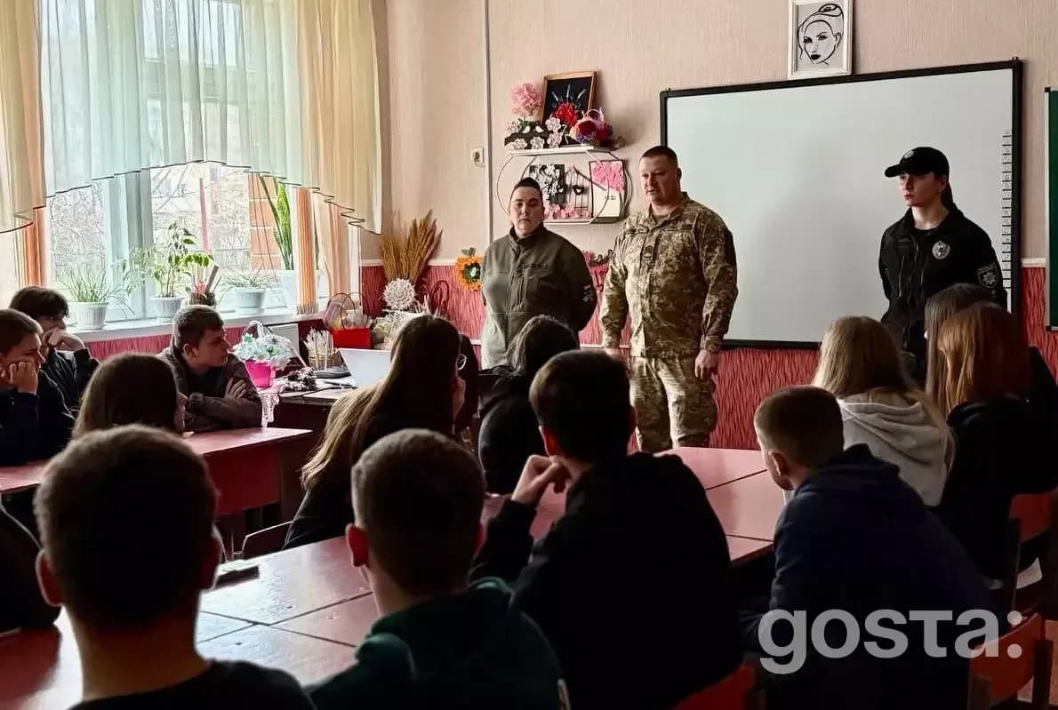 Троє офіцерів поліції проводять освітню бесіду з учнями в класі щодо безпеки та довіри.