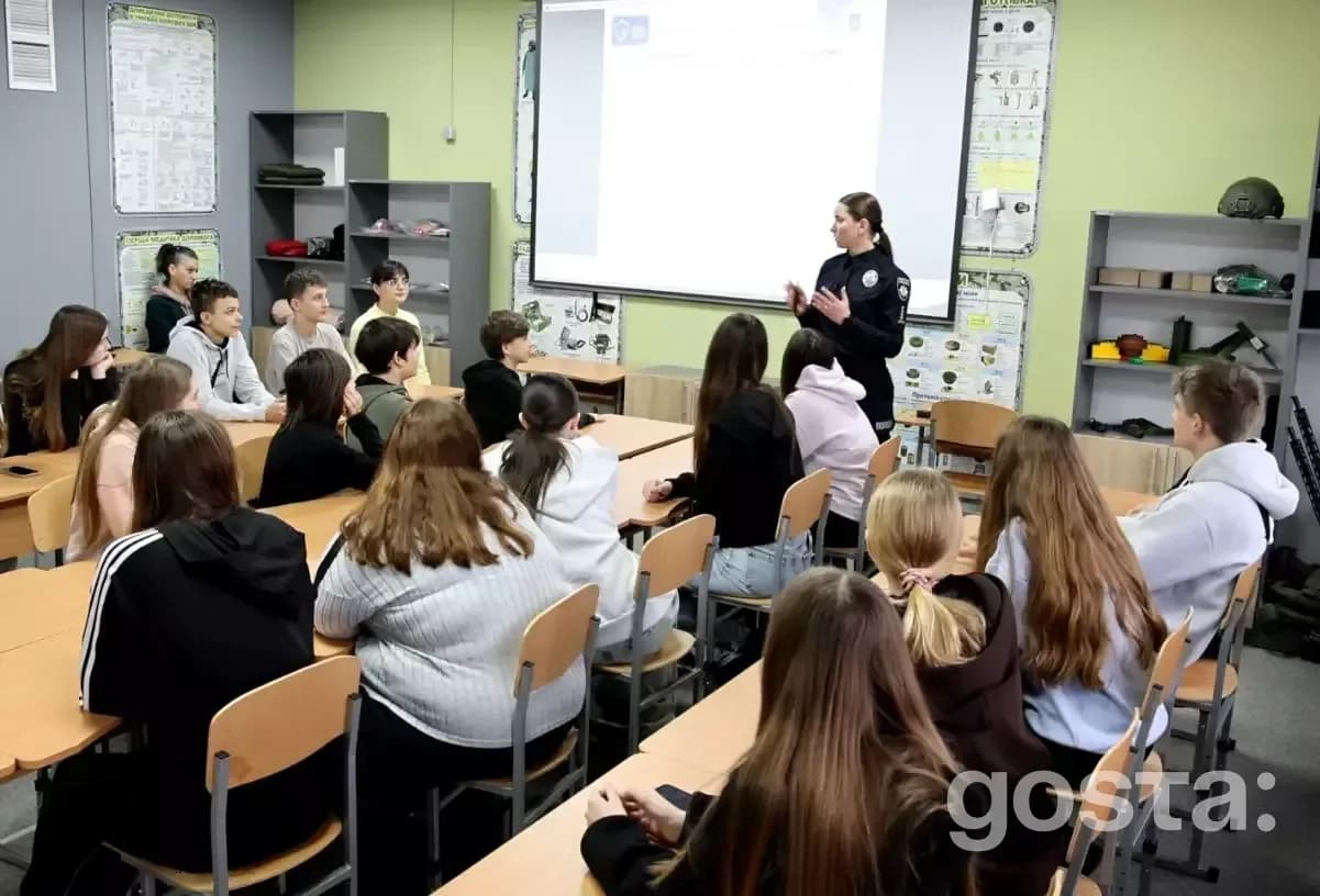 Поліцейська проводить інтерактивне заняття для учнів, обговорюючи безпеку та протидію булінгу в класній кімнаті.