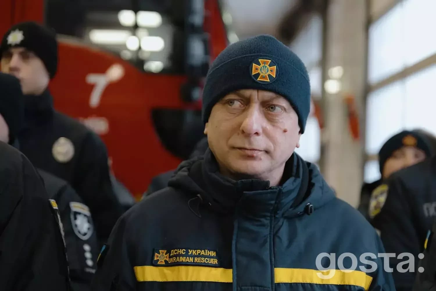 Чоловік у куртці ДСНС України на церемонії вручення нагород рятувальникам та поліцейським під час надзвичайних ситуацій.