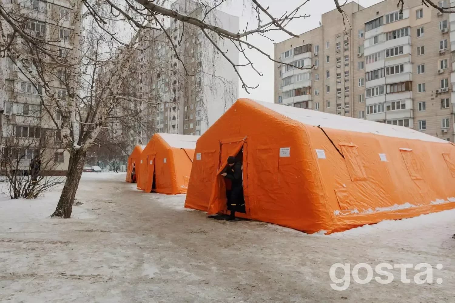 Тимчасові помаранчеві намети на снігу в міському районі для екстреної допомоги в Україні.