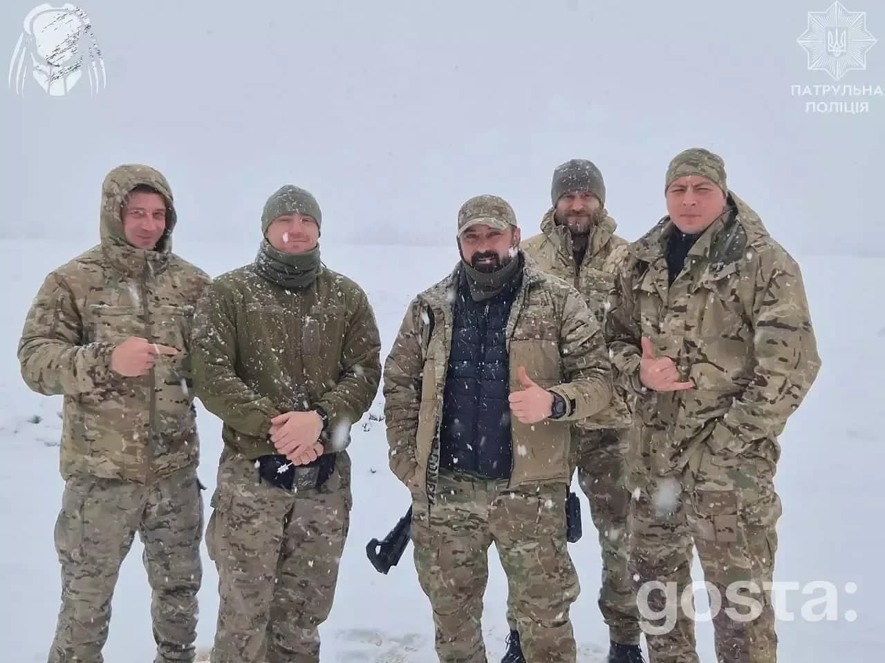 Бійці Національної поліції України в зимовій уніформі на засніженому фронті, командна фотографія.