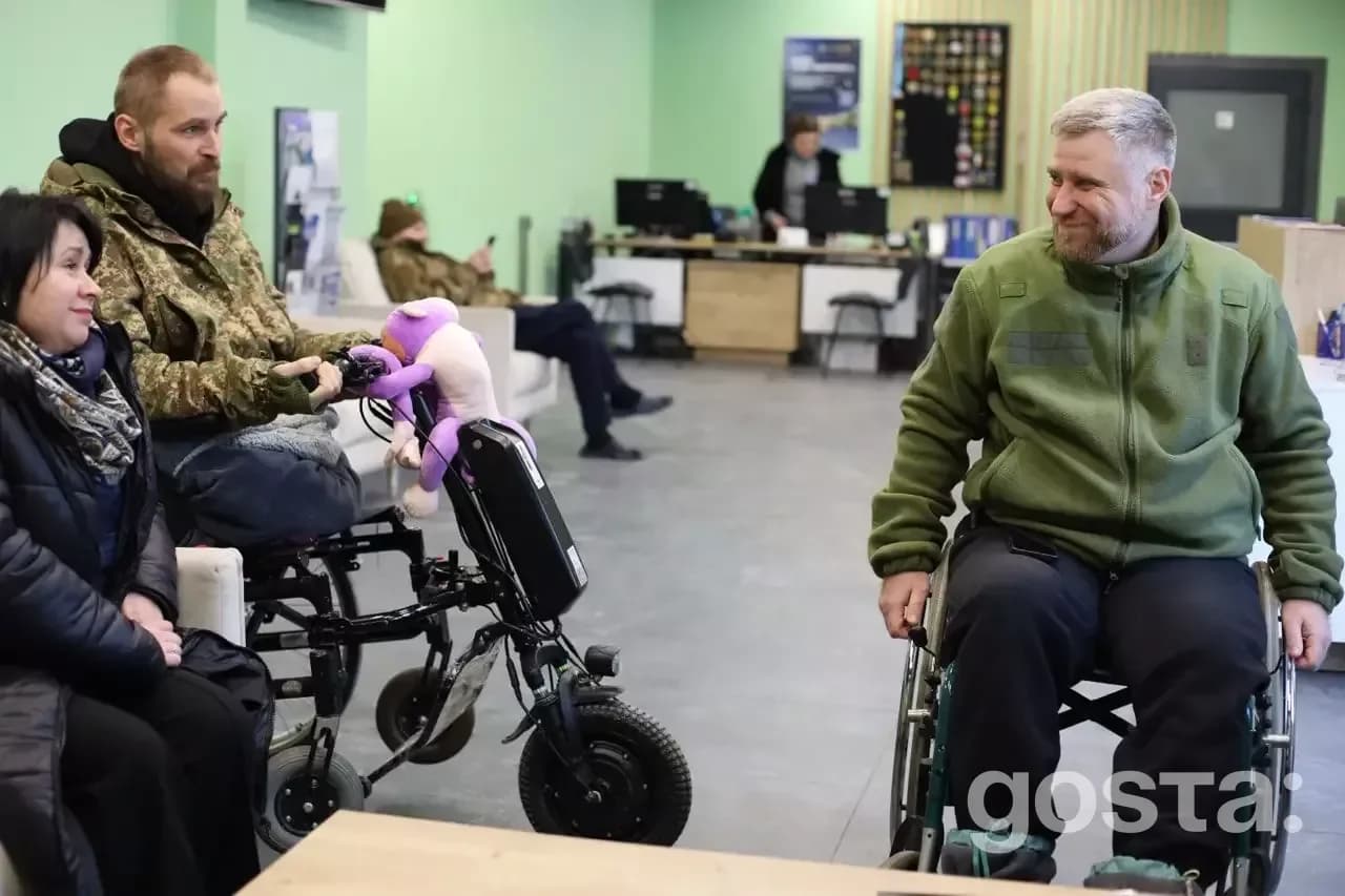 На зображенні люди в інвалідних візках в сервісному центрі МВС, отримують консультації та підтримку.