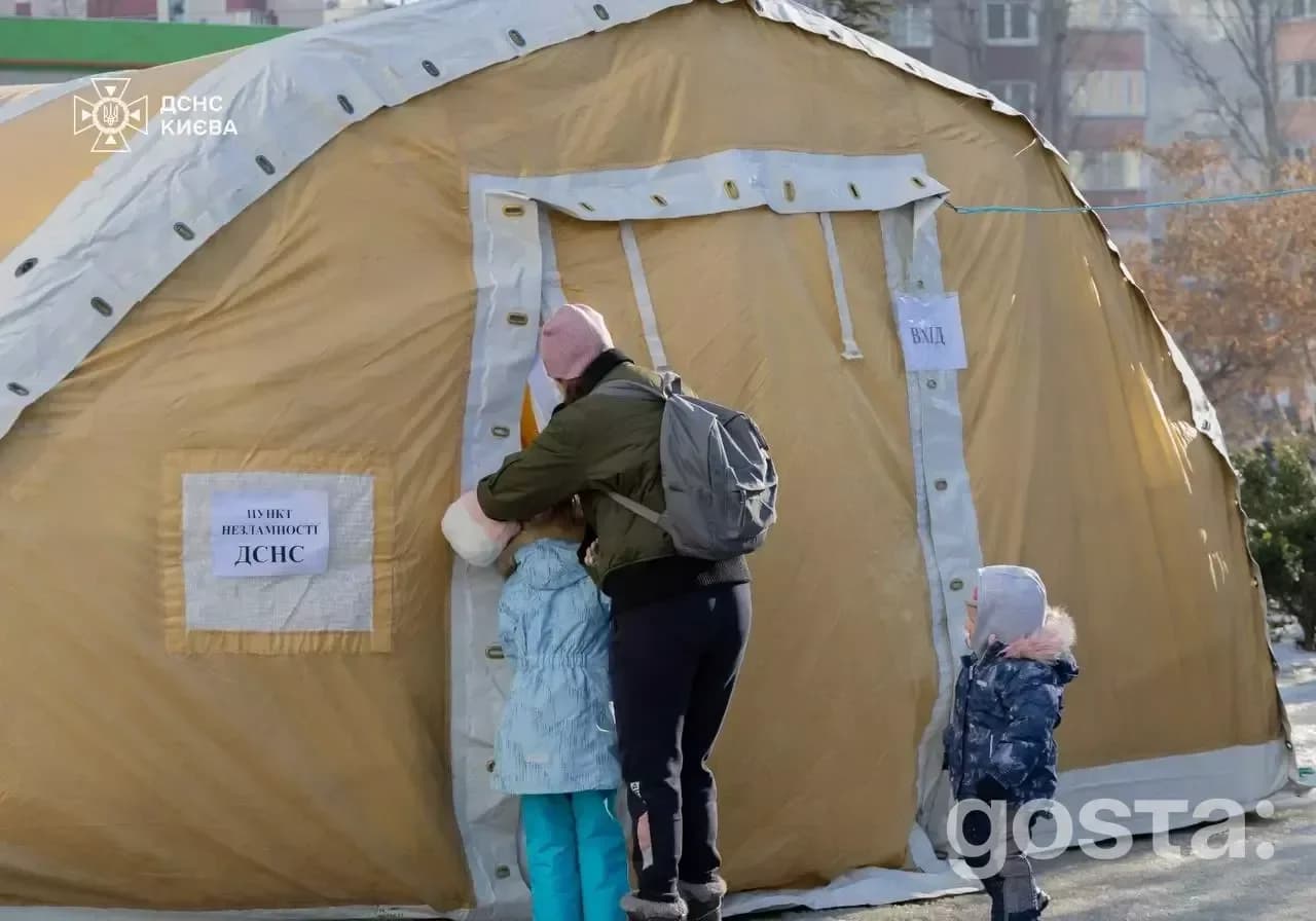 До зображення: Люди біля намету "Пункт незламності ДСНС" у Києві, забезпечують тепло та підтримку під час енергокризи.