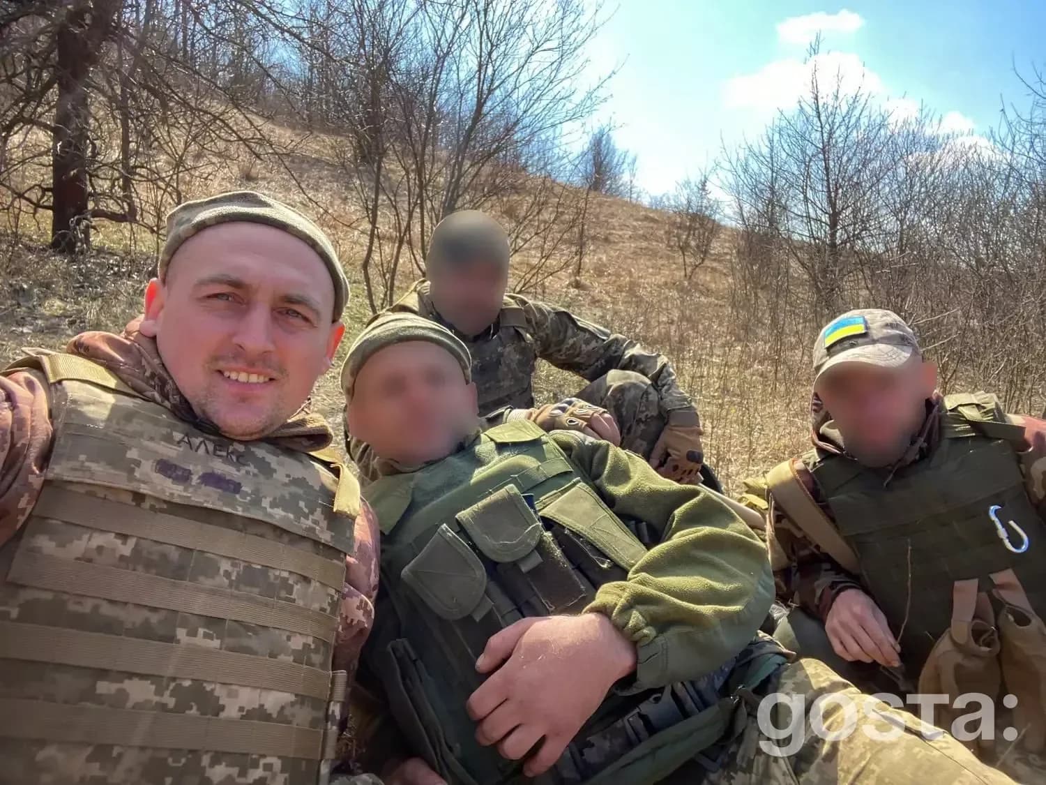 Ветерани у військовій формі відпочивають на природі; один військовослужбовець усміхається на камеру.
