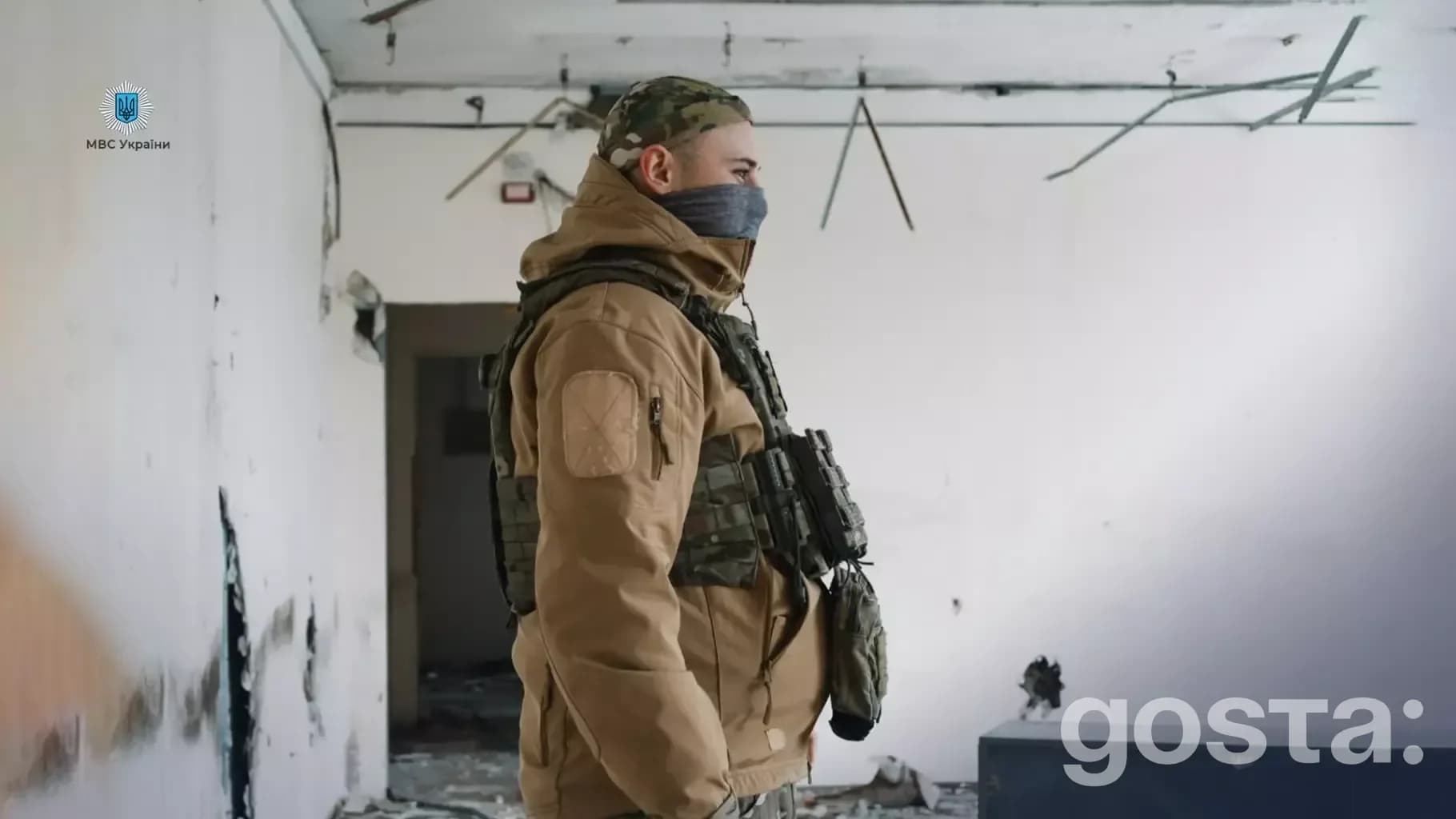 Прикордонник стоїть у напівзруйнованій будівлі, одягнений у військову форму, готовий до виконання завдань.