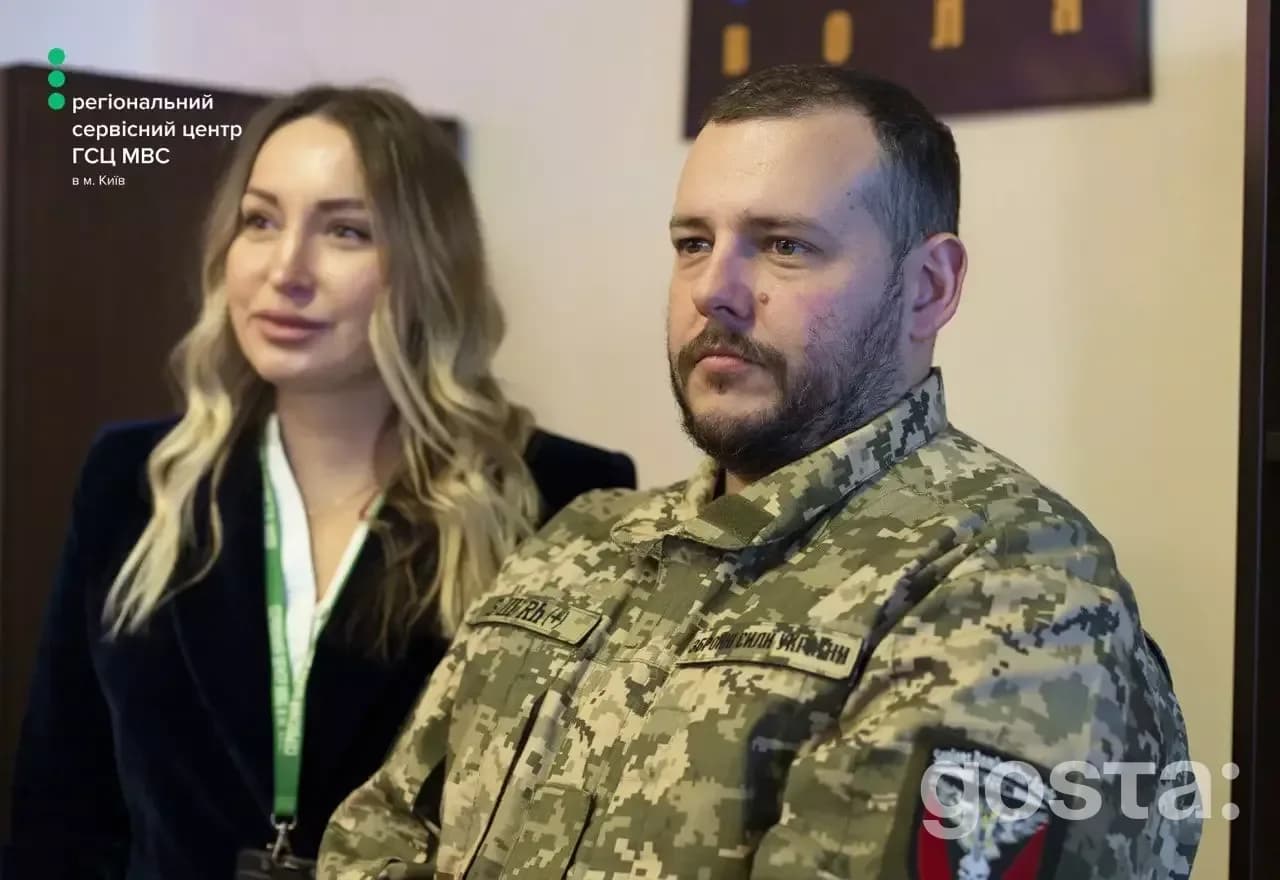 На зображенні чоловік у військовій формі та жінка в сервісному центрі МВС у Києві.