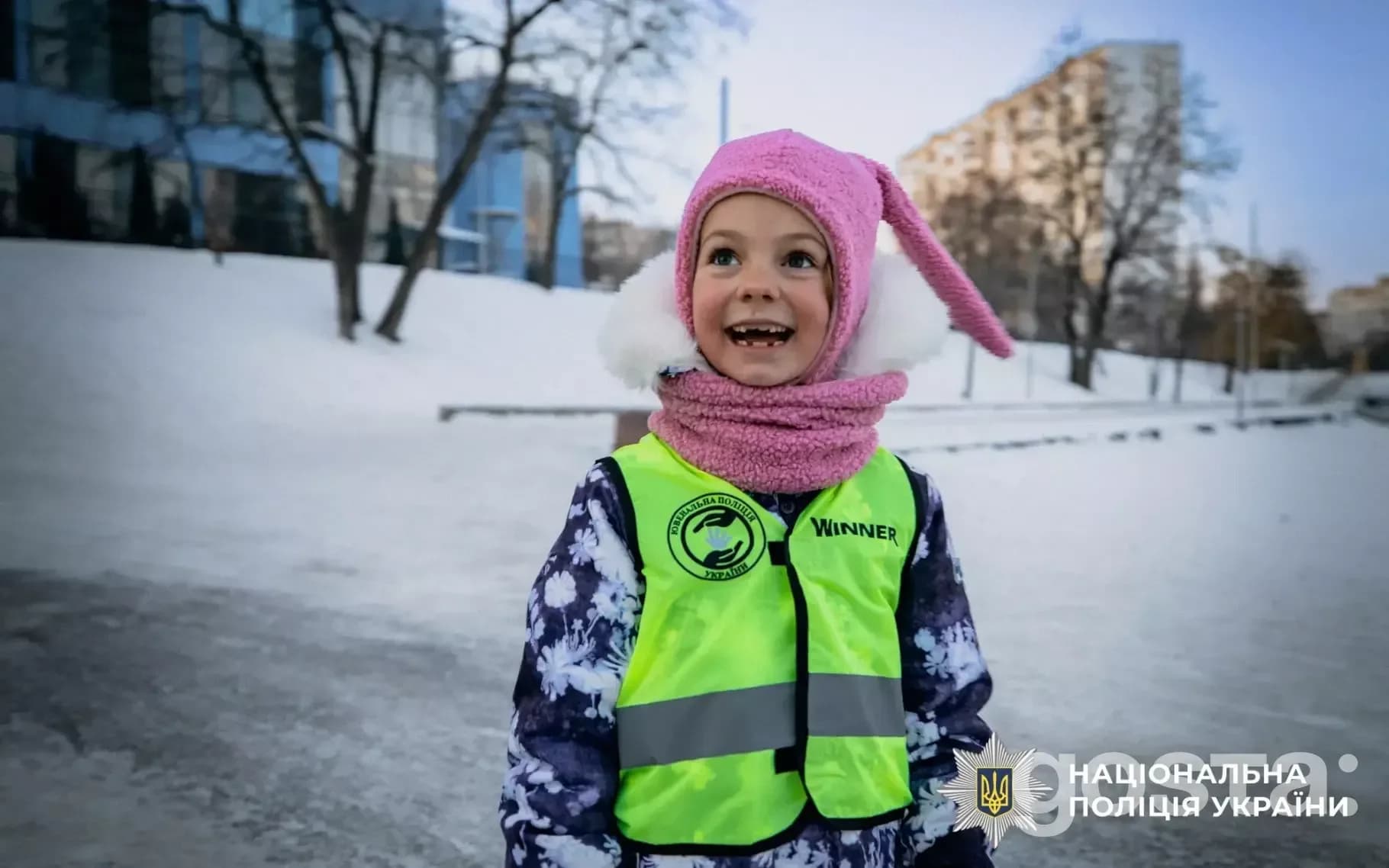 Дитина в світловідбивальному жилеті на зимовій прогулянці, Національна поліція України, безпечна поведінка на вулиці.