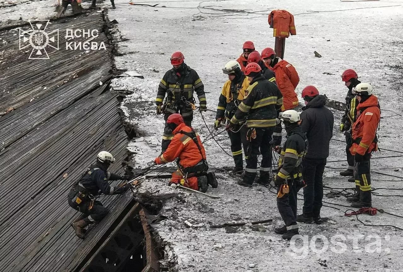 Рятувальники ДСНС працюють на зруйнованій будівлі взимку в Києві. Команда в захисному одязі проводить роботи.