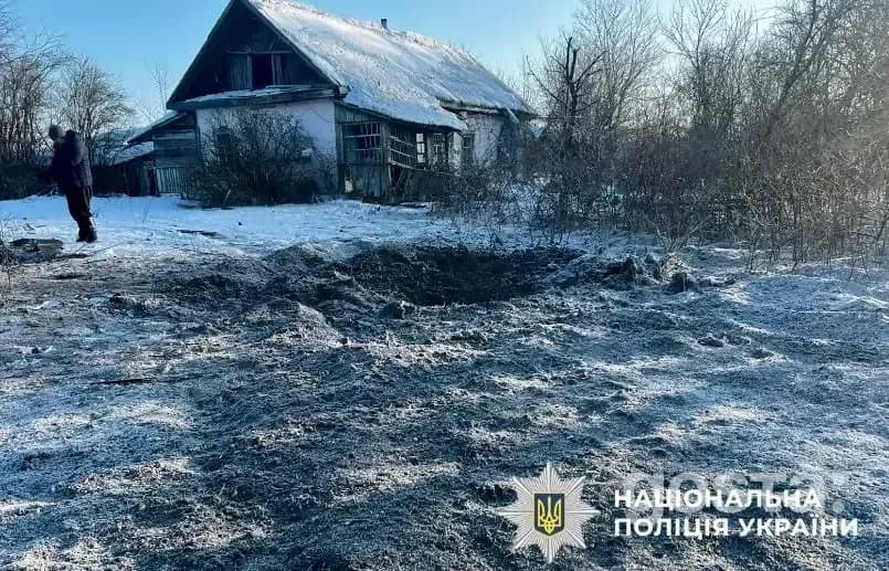Наслідки обстрілів: зруйнований двір біля пошкодженого будинку, сніг та сліди вибухів; зима в Україні.