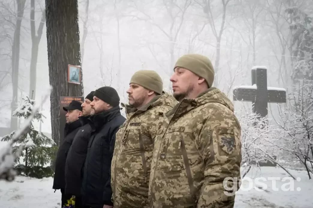 На зображенні зображена група чоловіків у військовій формі, що вшановують пам'ять Героїв Крут на Аскольдовій могилі.