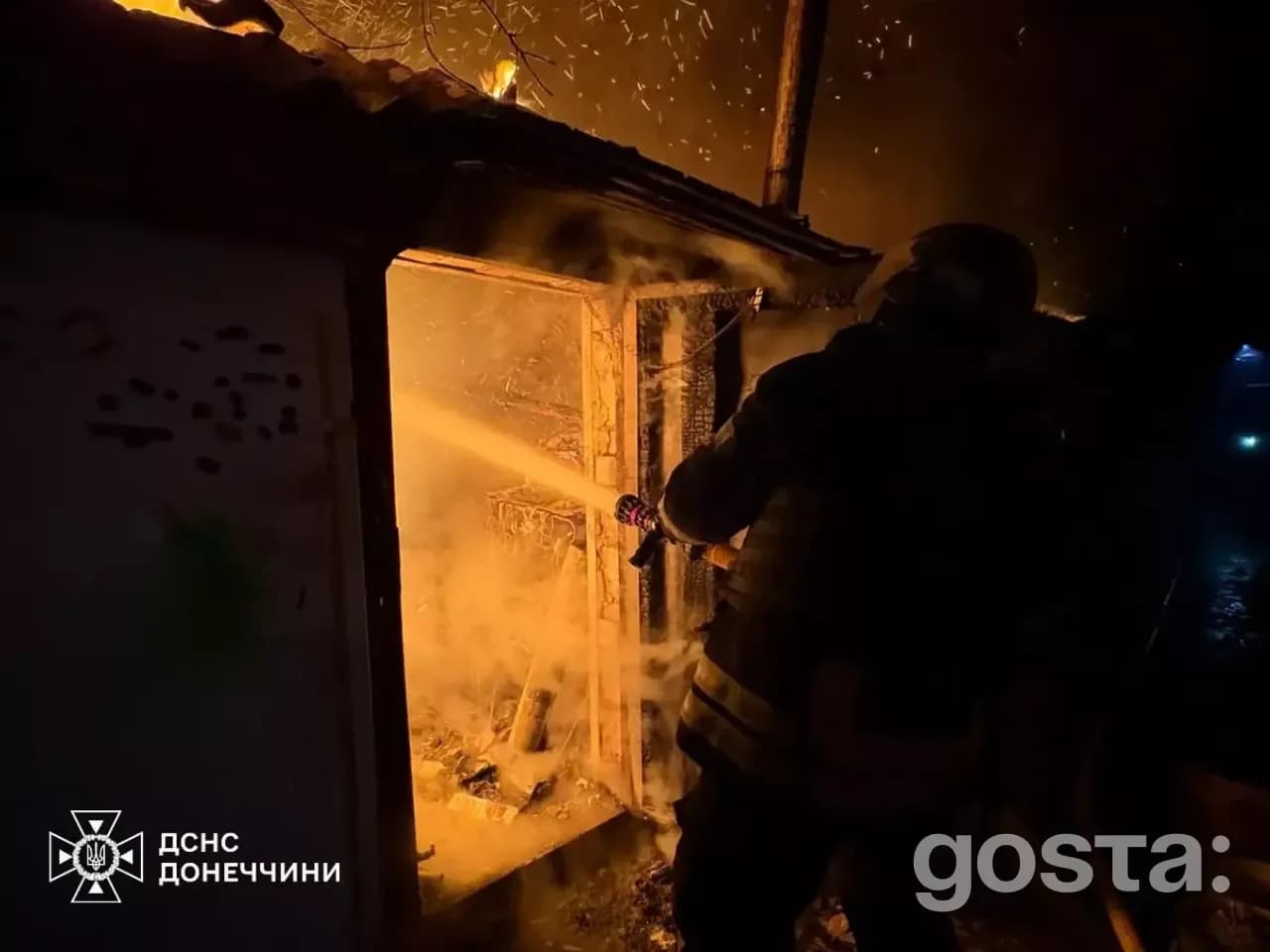 Рятувальник гасить вогонь під час нічної атаки. Критична інфраструктура, Україна, обстріл, відновлення.