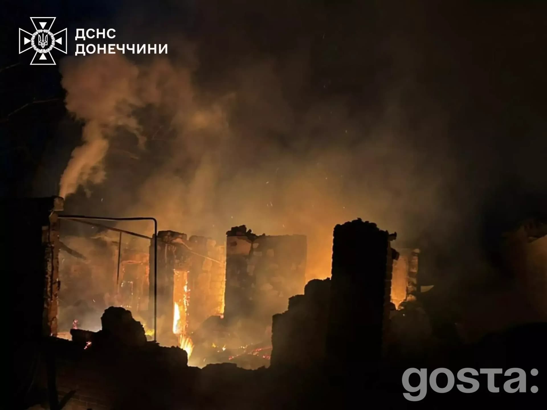 Зображення наслідків обстрілів на Донеччині: пожежа в зруйнованій будівлі, густий дим піднімається в нічному небі.