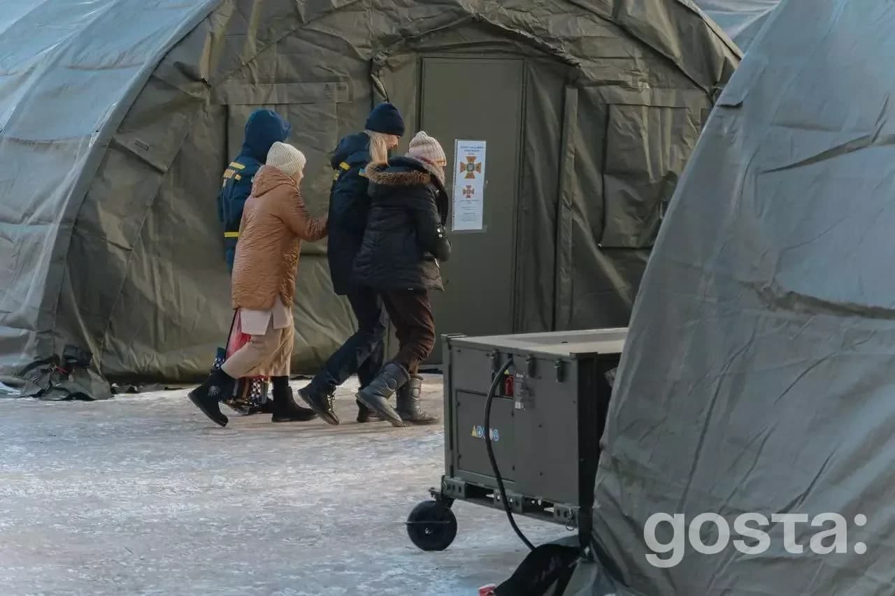 Люди заходять у намет обігріву ДСНС у зимовому Києві, організованому для підтримки під час гуманітарної кризи.