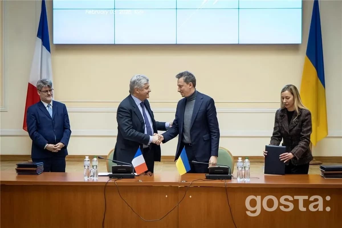 Зустріч міністрів України та Франції з економічного співробітництва, рукостискання, прапори та документи.