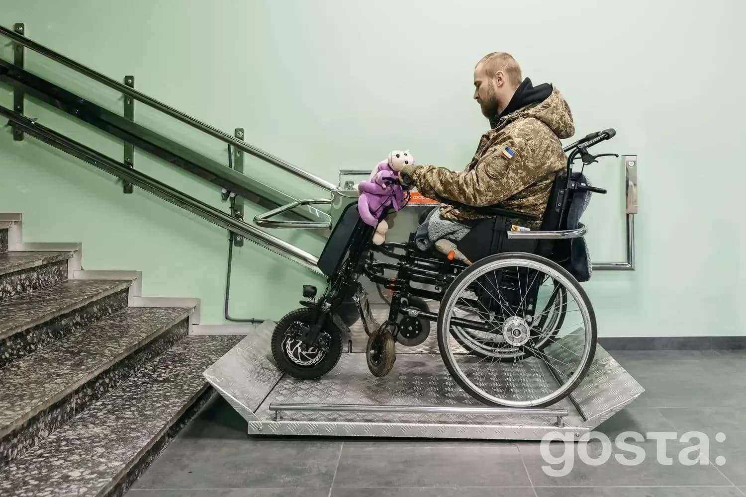 Чоловік на інвалідному візку з електроприводом долає сходи в медичному центрі МВС України.
