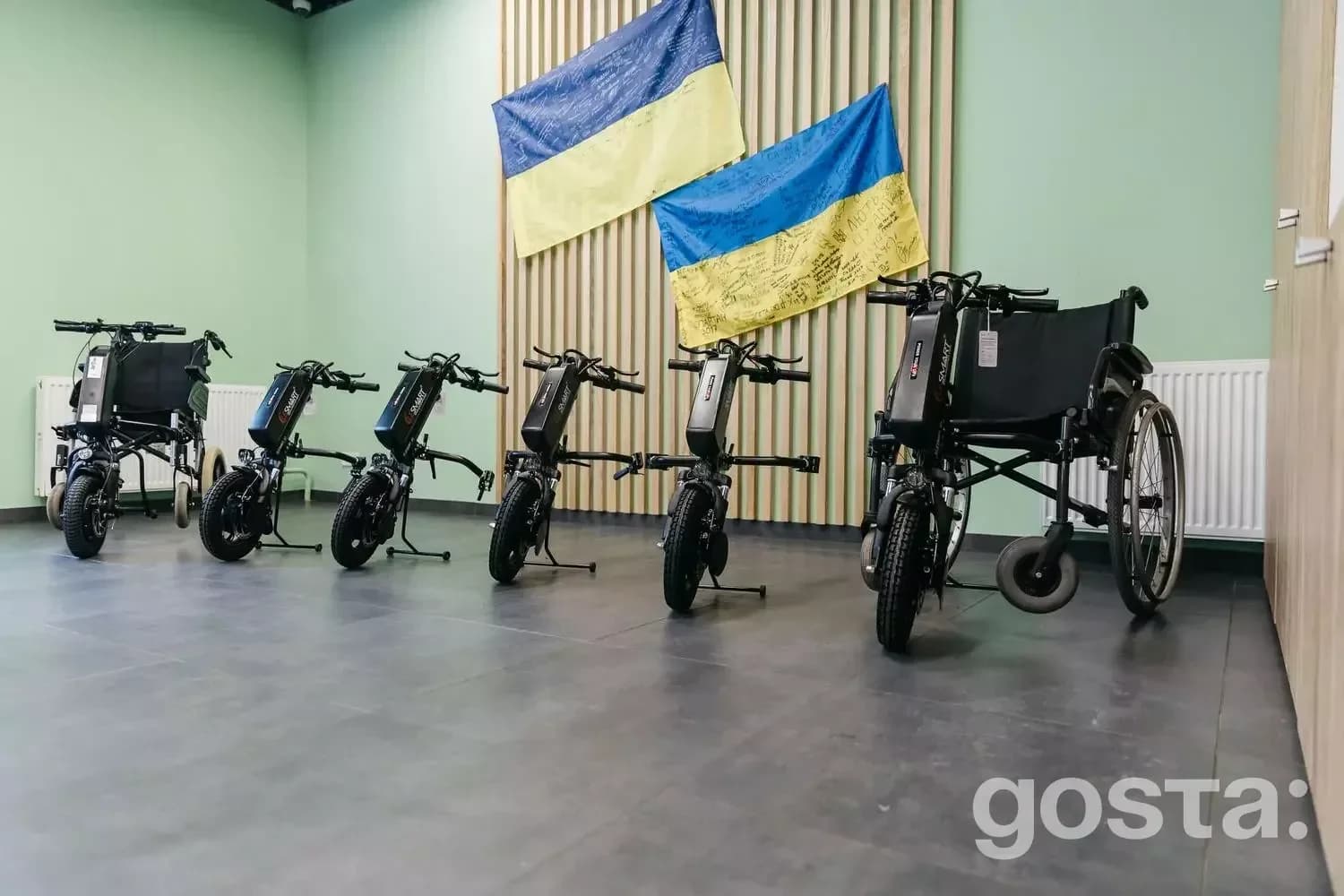 Реабілітація ветеранів: електроприводи для крісел колісних на тлі прапорів України у медичному центрі.