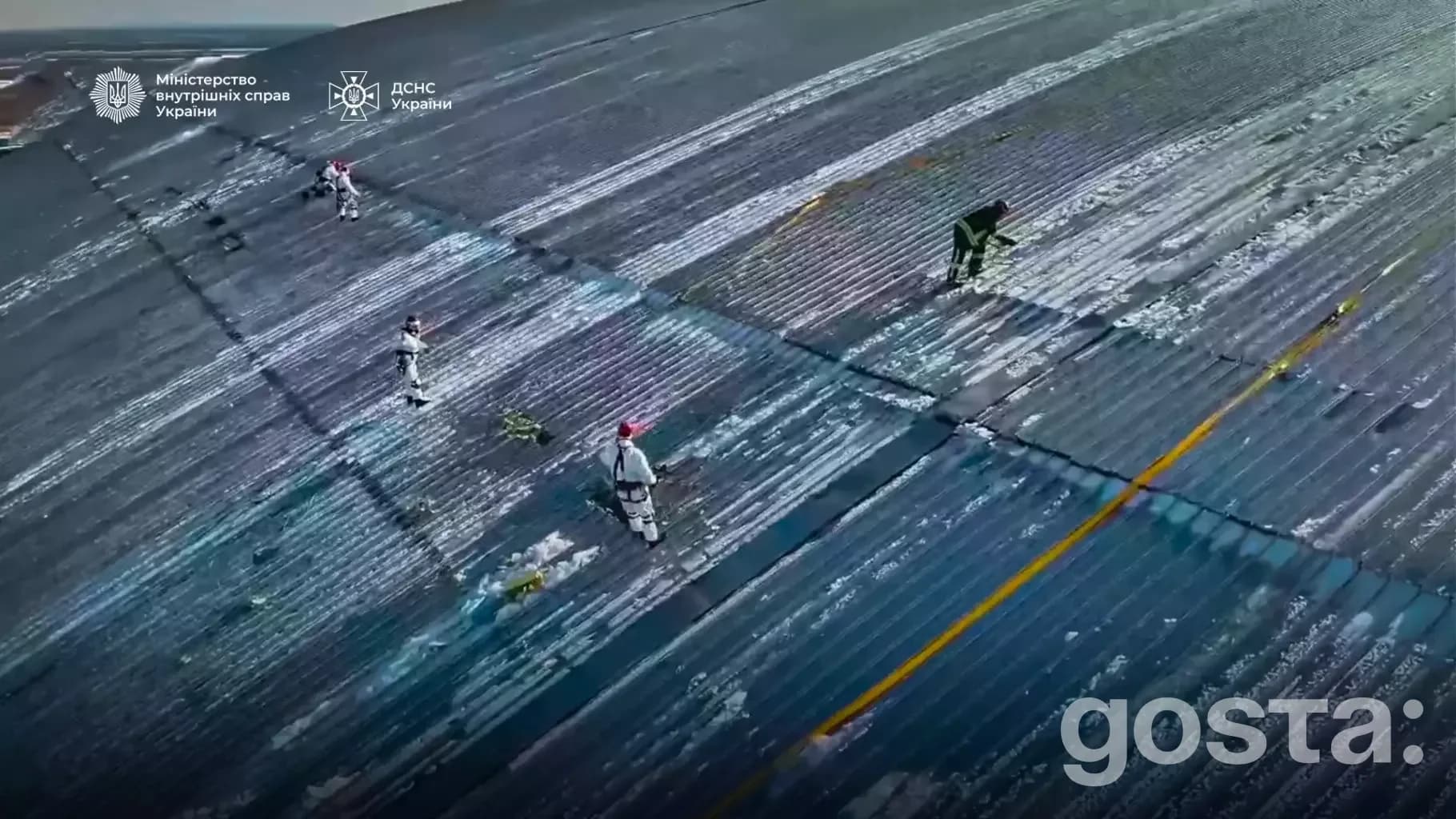 На зображенні рятувальники ДСНС України працюють на даху зруйнованої будівлі.