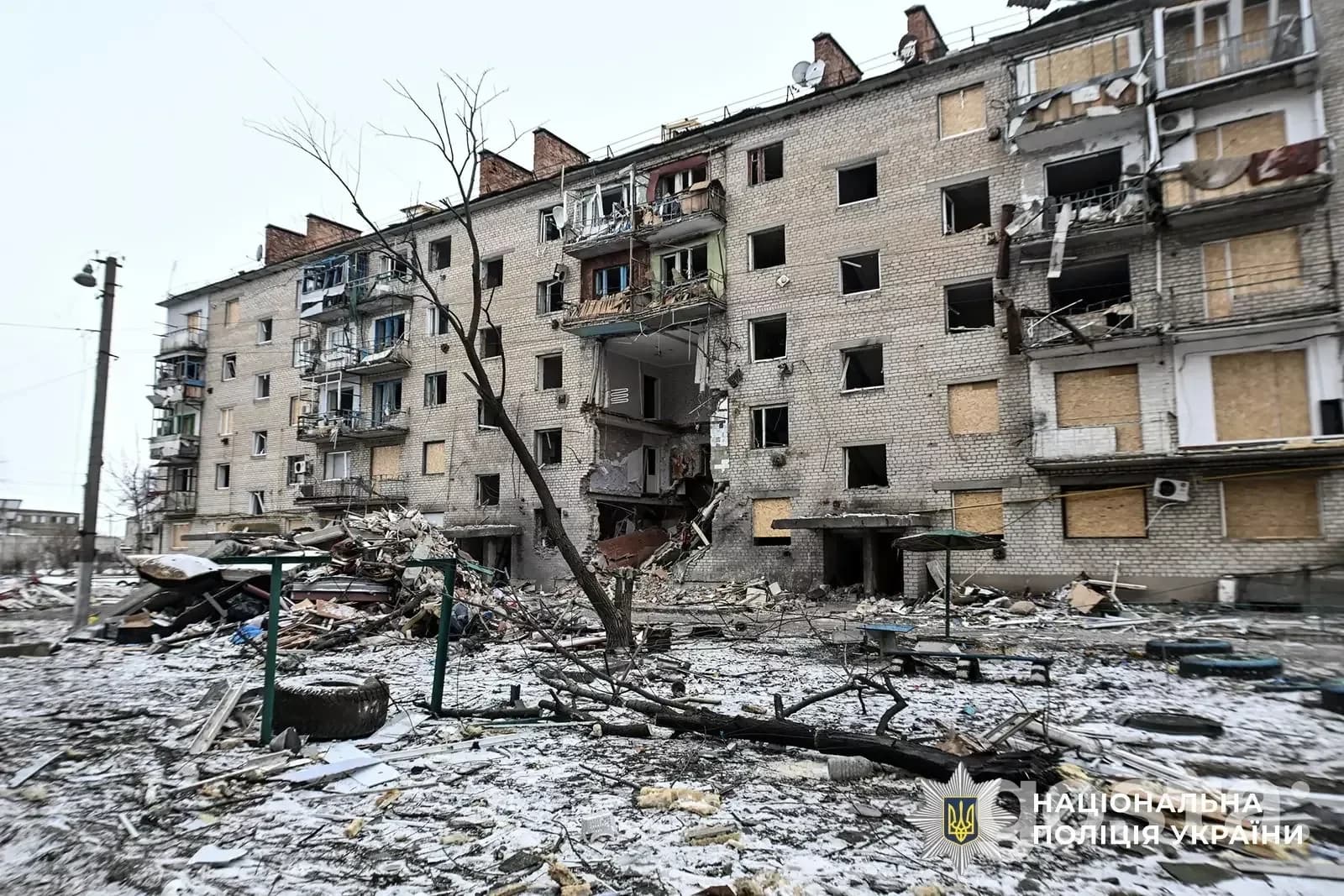 Зруйнований багатоповерховий будинок після обстрілу в Донецькій області, уламки та пошкодження фасаду.