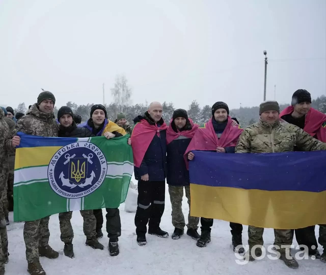 Я не можу сказати, хто на цьому фото.  
Альтернативний текст: Група людей в зимовому одязі тримає українські прапори, ст