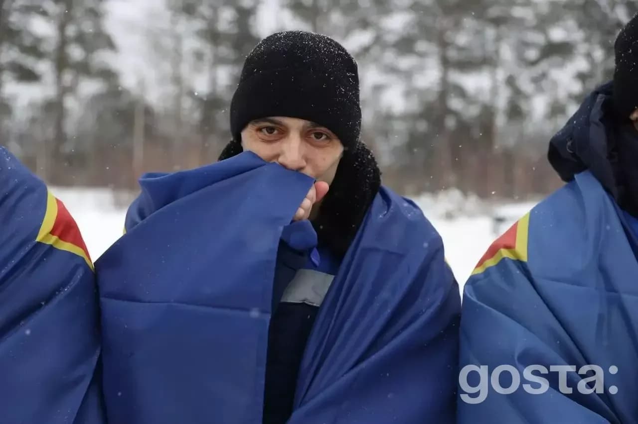 Військовий у теплому одязі, зима, повернення з полону, український захисник, засніжений ліс на тлі.