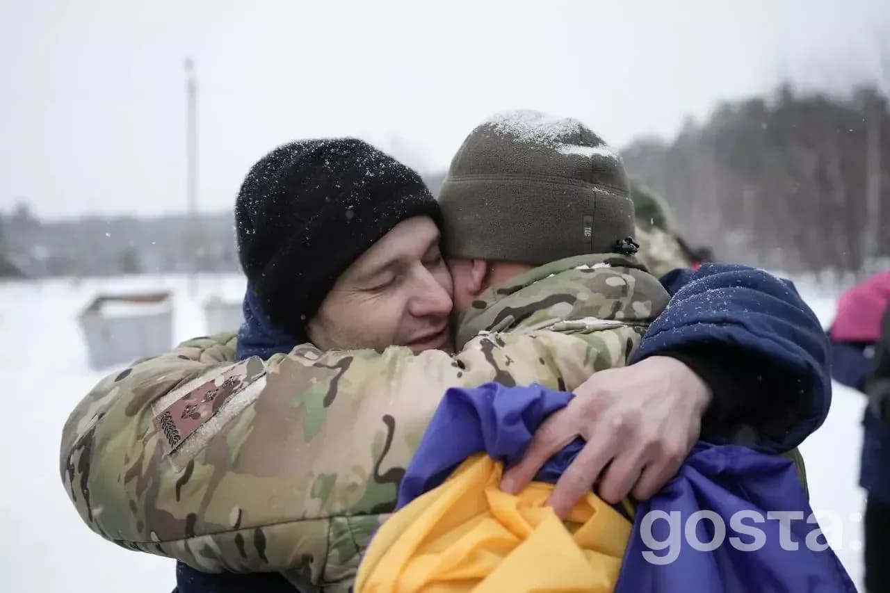На зображенні двоє військових щиро обіймаються на тлі зимового пейзажу, символізуючи повернення додому.