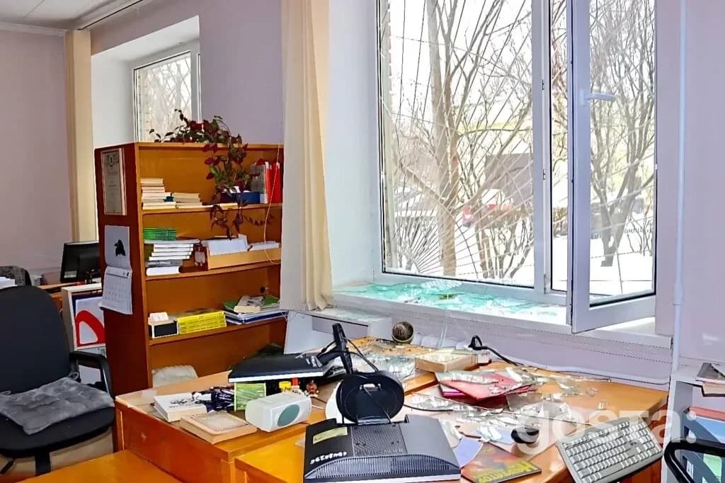 На фото зображено пошкоджений інтер'єр дитячої бібліотеки з розбитими вікнами після атаки.