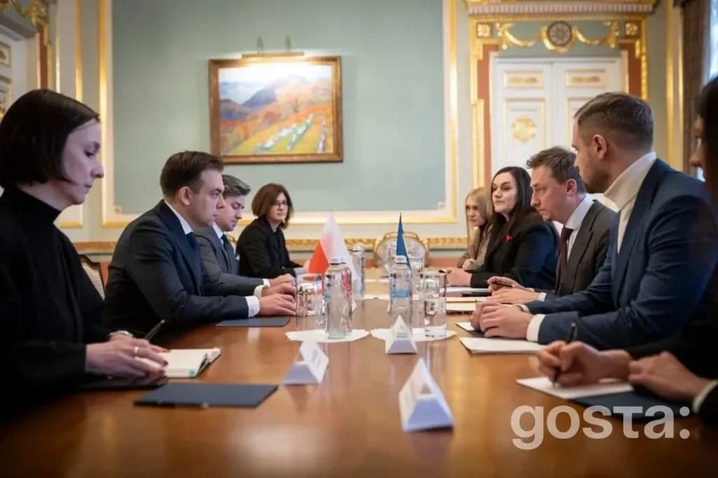 Лідери делегацій України та Польщі під час офіційної зустрічі у приміщенні з прапорами на столі.