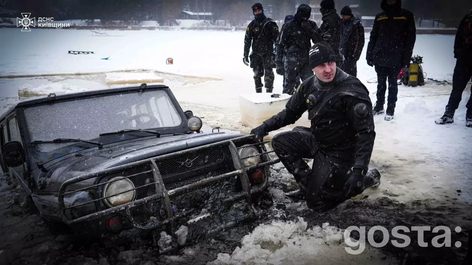 Рятувальники біля автомобіля, що провалився під лід на Київщині, під час пошукових робіт на замерзлій водоймі.