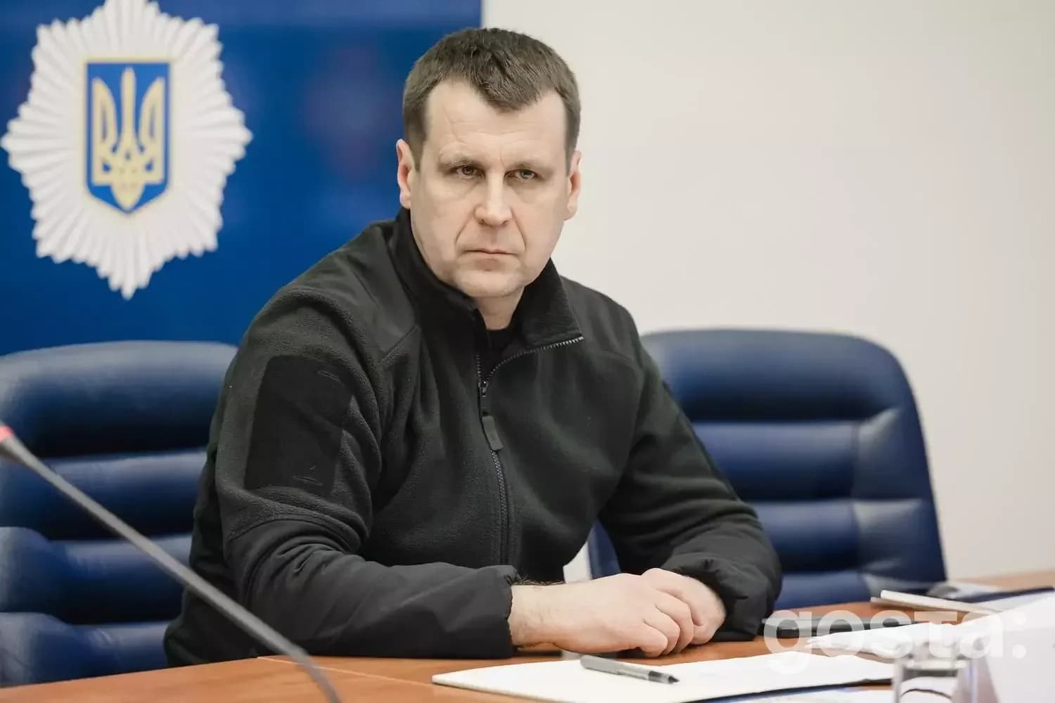 На зображенні зображено офіційну зустріч представника МВС України на тлі емблеми з символом держави.
