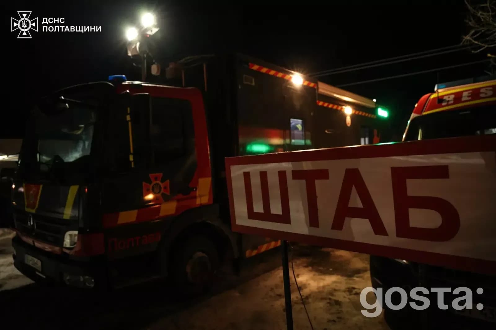Рятувальники ДСНС України вночі біля штабу, вантажівки з увімкненими фарами, Полтавщина.