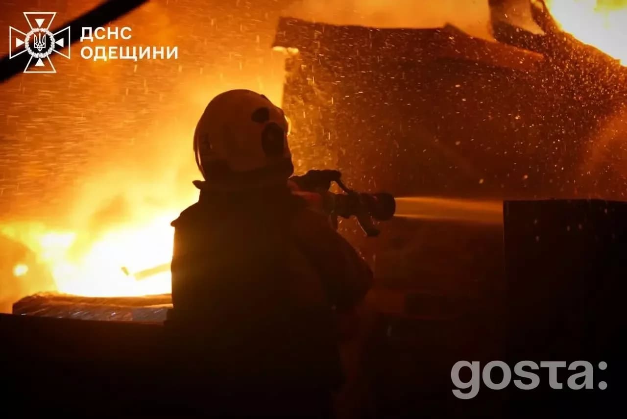 Пожежник бореться з вогнем на тлі руйнувань після обстрілів в Україні.