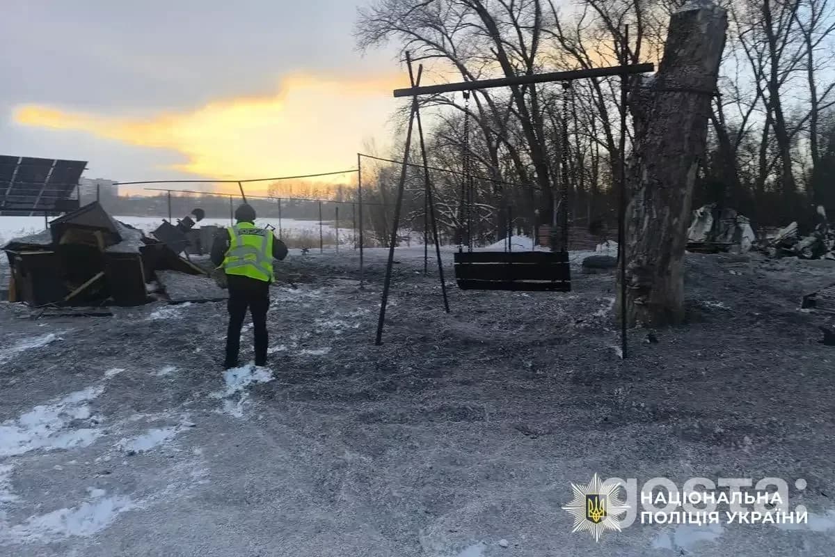 Поліцейський на місці обстрілів в Україні, зруйнована інфраструктура, зимовий пейзаж.
