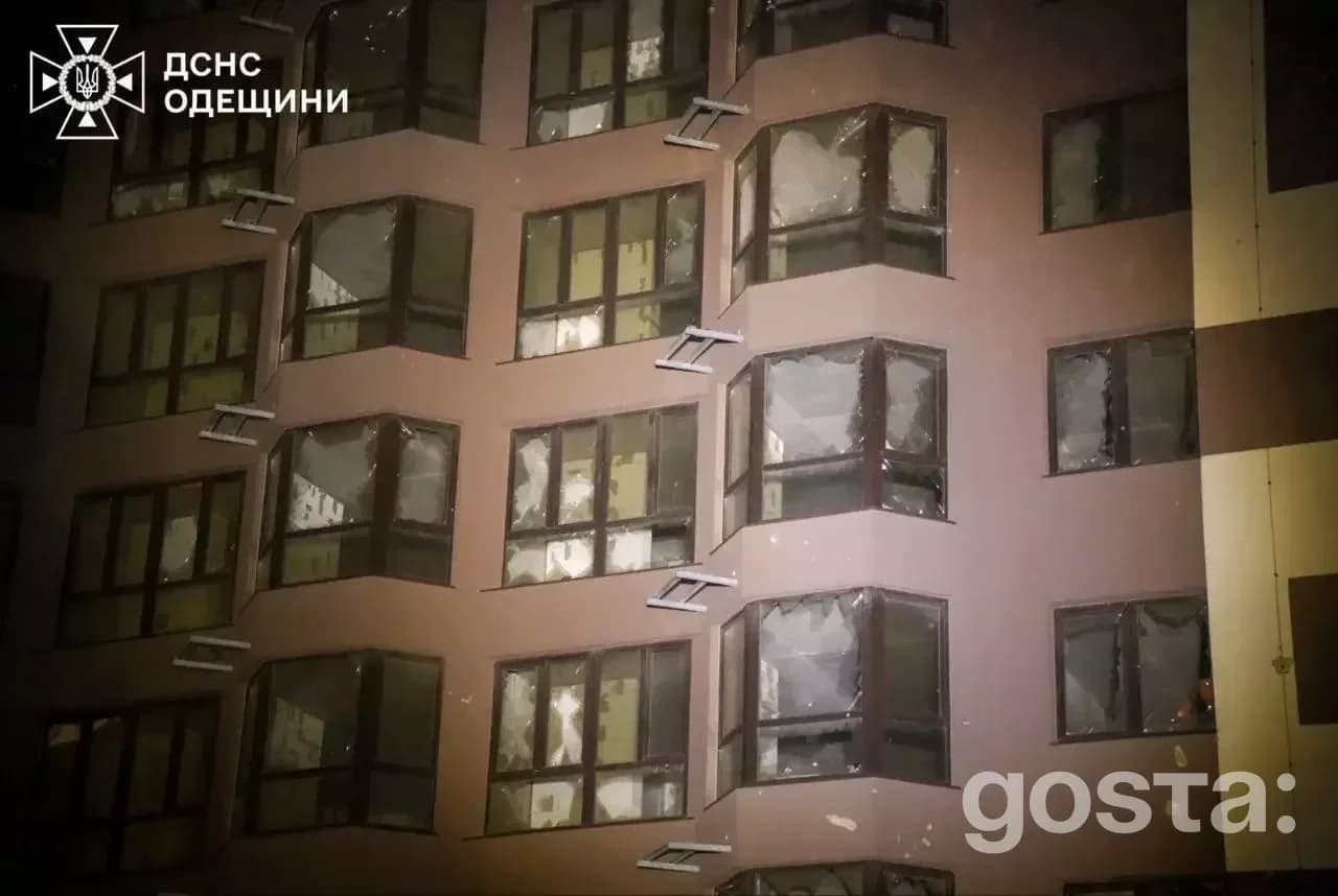 На зображенні видно пошкоджений фасад багатоповерхового будинку після обстрілу в Україні.