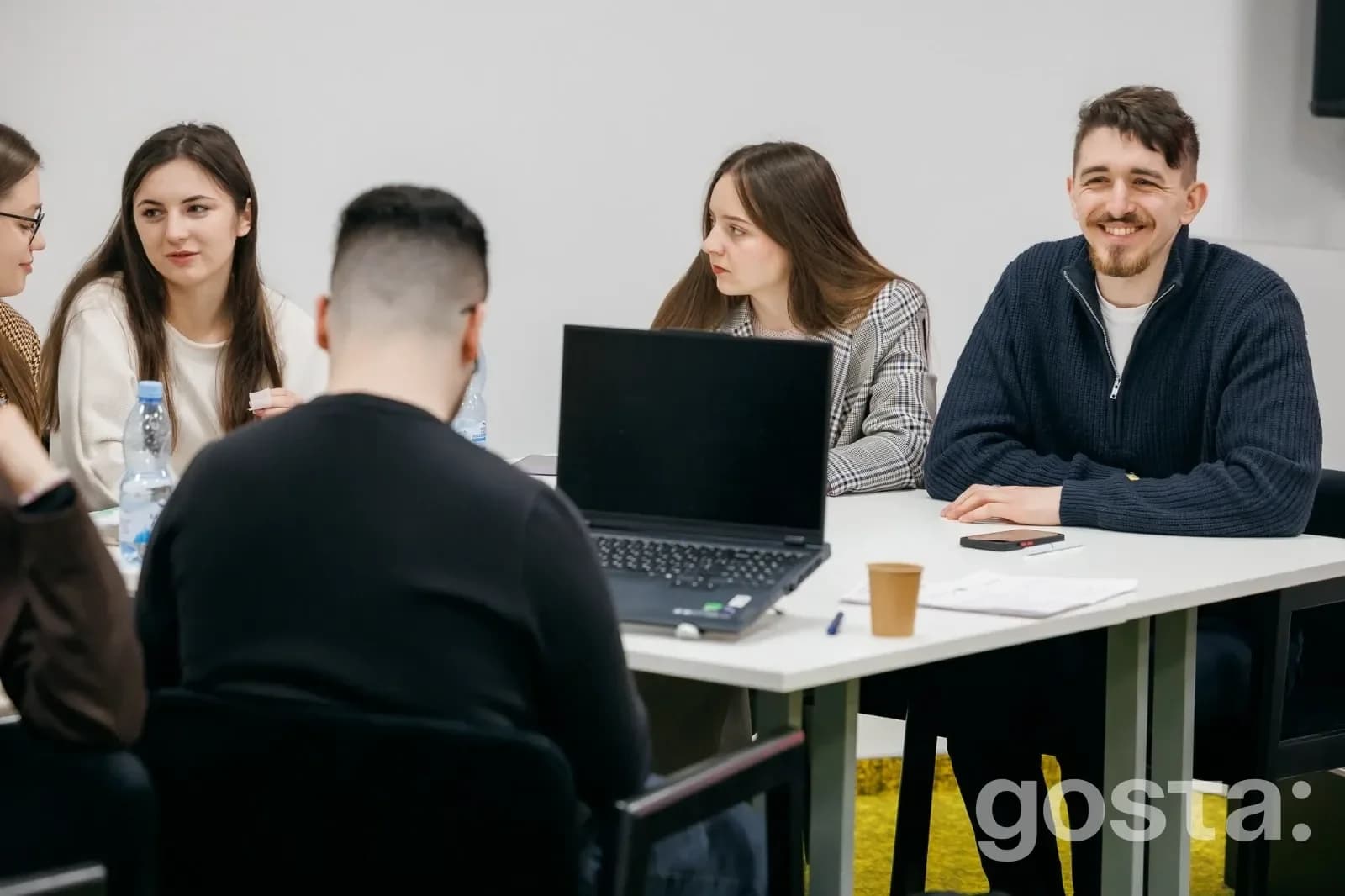 На фото група молодих людей за столом на фасилітованій зустрічі молодіжних рад у Києві.
