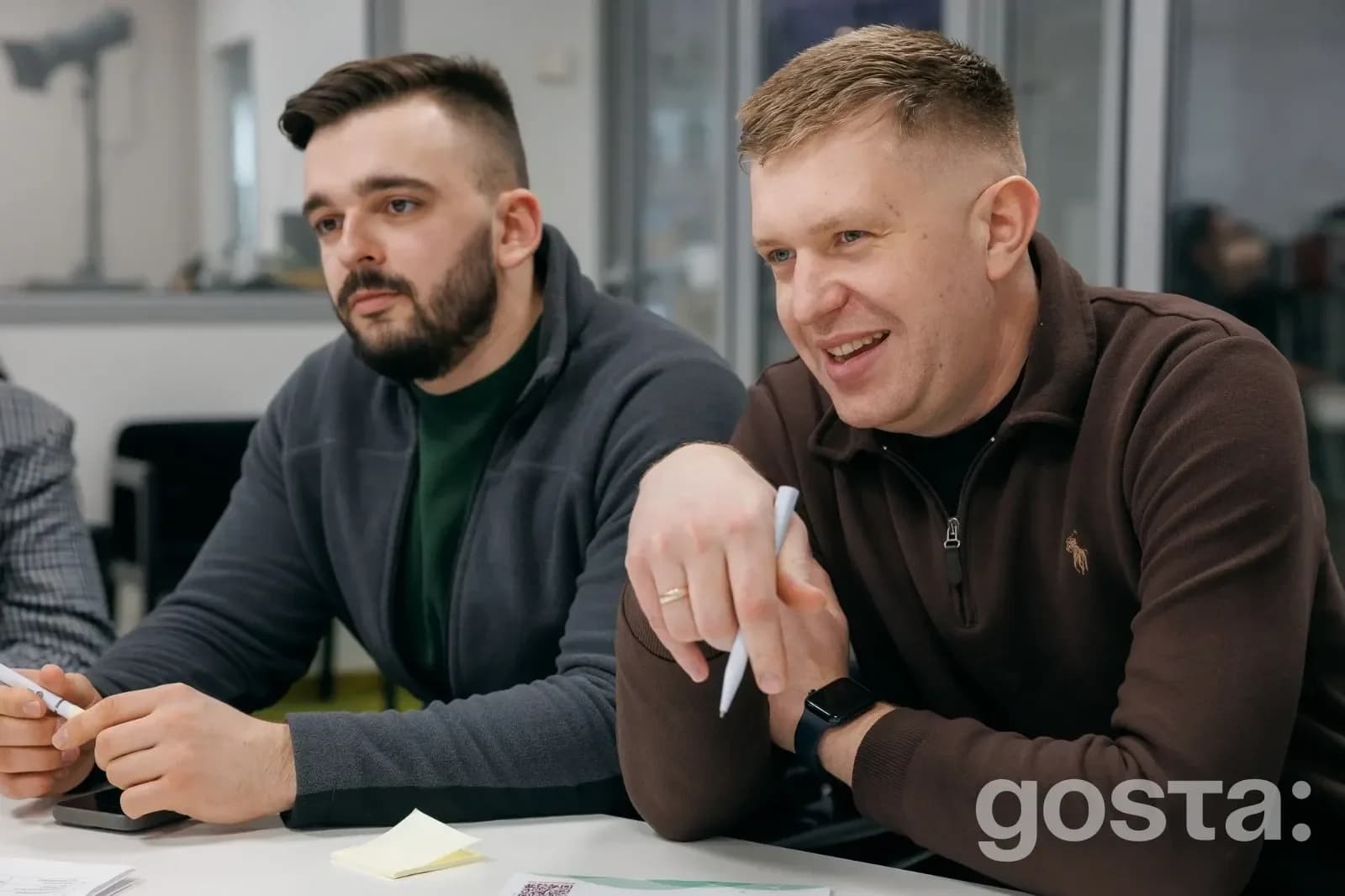 На фото двоє чоловіків активно беруть участь в обговоренні на фасилітованій зустрічі молодіжних рад у Києві.