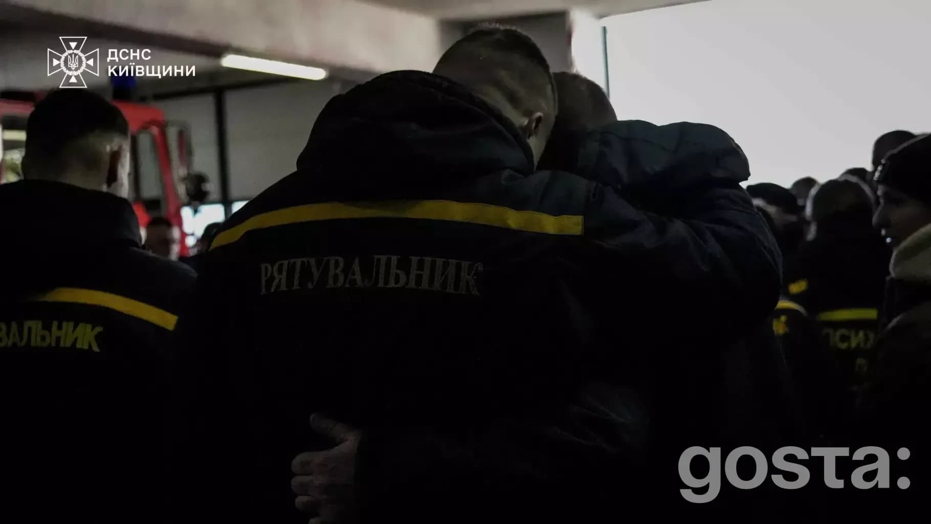 На зображенні люди в чорних куртках ДСНС на церемонії прощання з рятувальником у Київській області.
