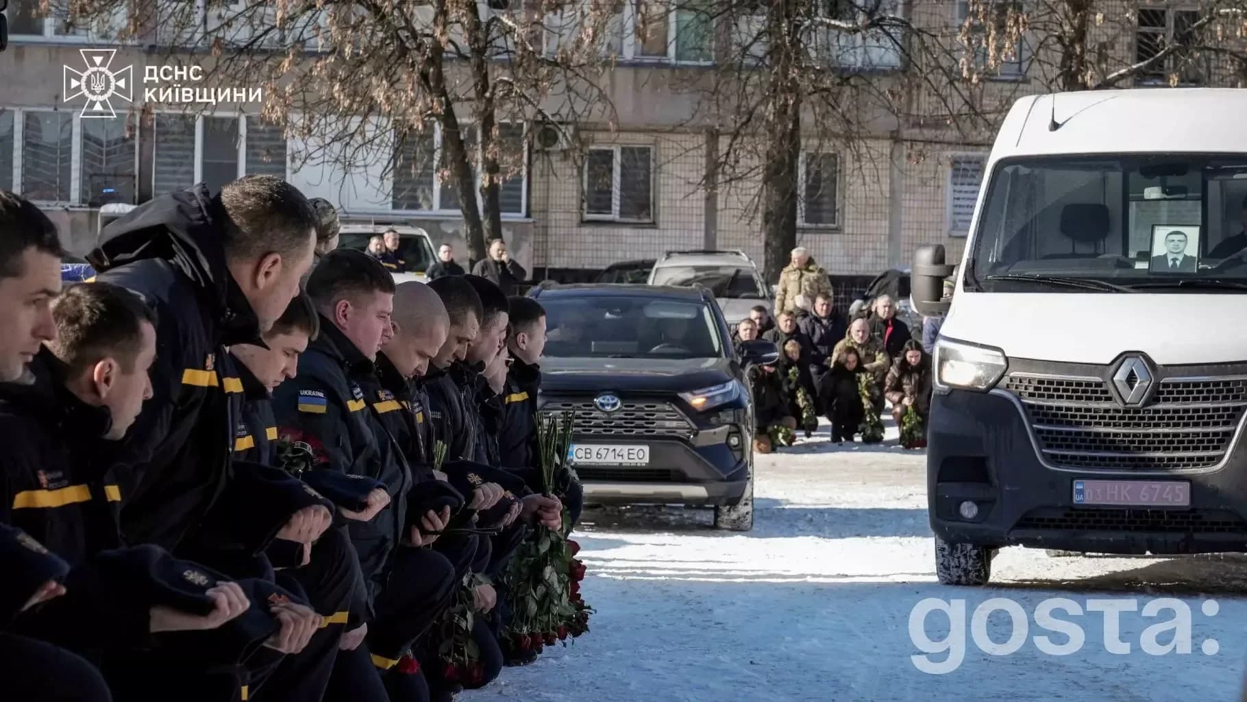 На Київщині вшанування пам'яті рятувальника Михайла Проценка, побратими на колінах перед поховальним автомобілем.