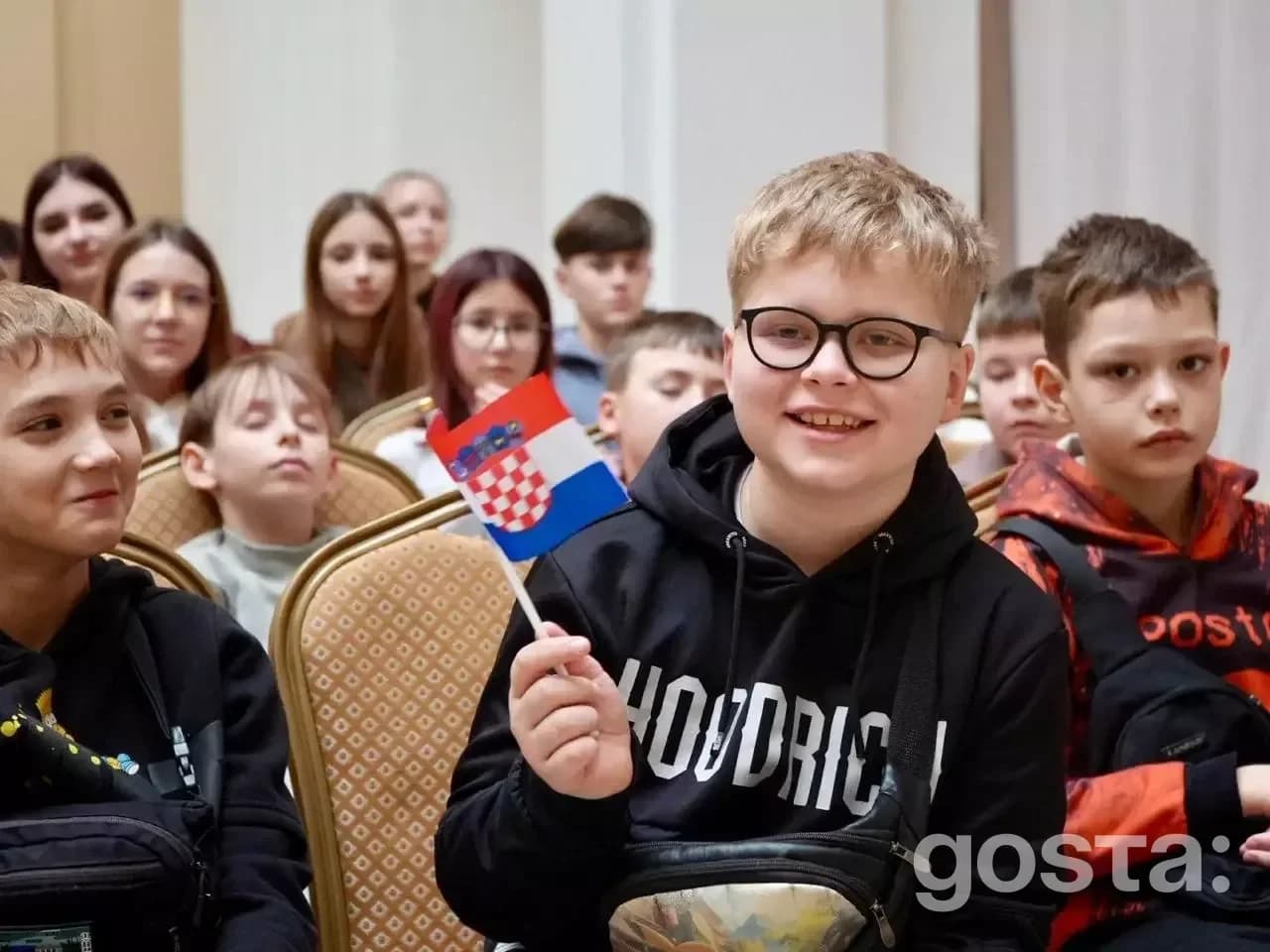 Діти загиблих і поранених захисників України відпочивають у Хорватії, тримаючи хорватський прапор.