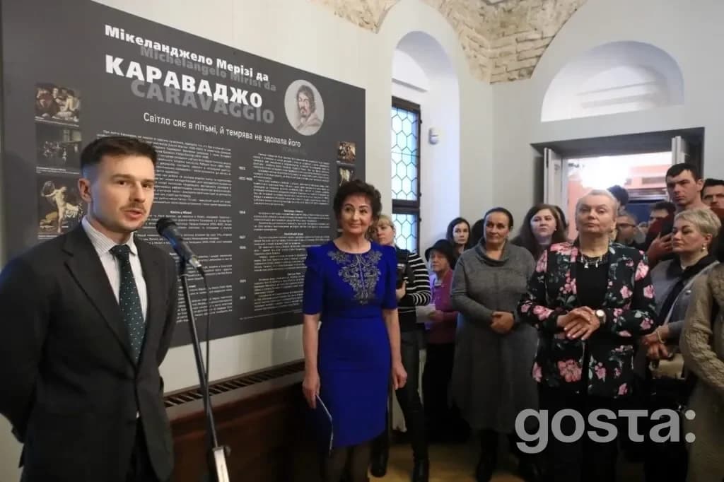 На виставці у «Софії Київській» люди слухають презентацію про реставрацію картини Караваджо "Взяття Христа під варту".