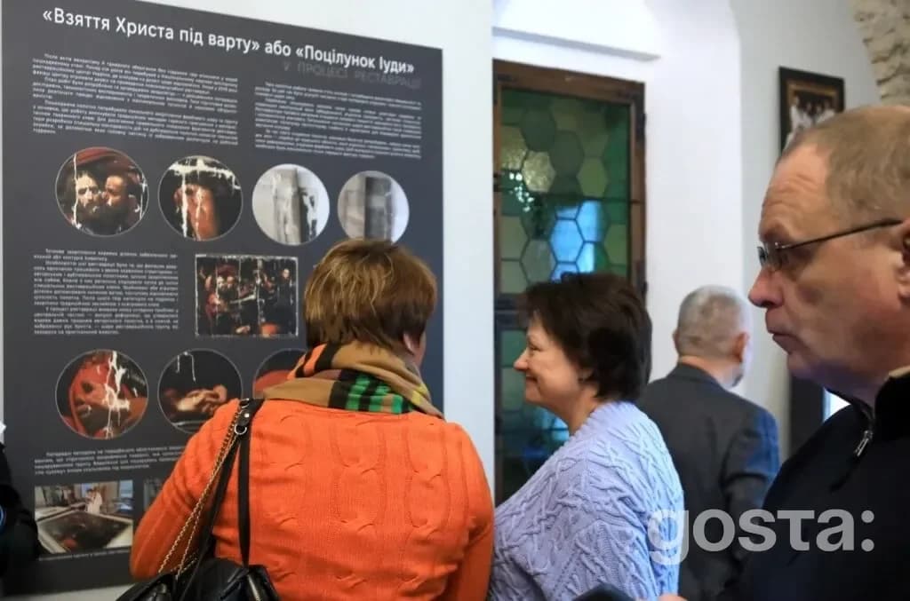 На фото відвідувачі оглядають інформаційний стенд на виставці «У світлі Караваджо» в Софії Київській.
