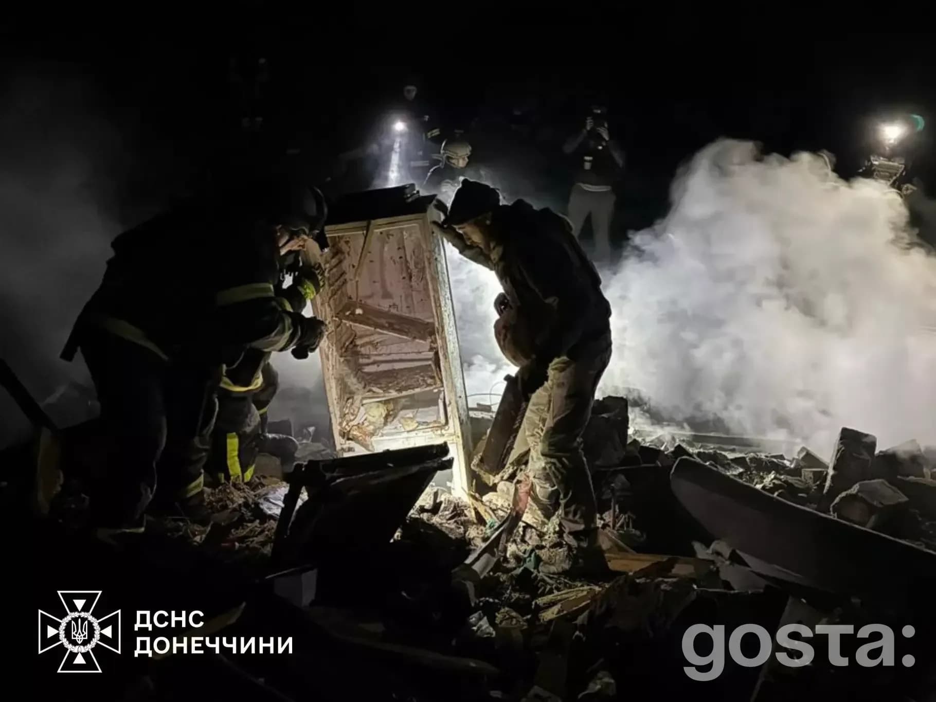 Рятувальники досліджують руїни після атак в Донецькій області, нічний час, дим, уламки.