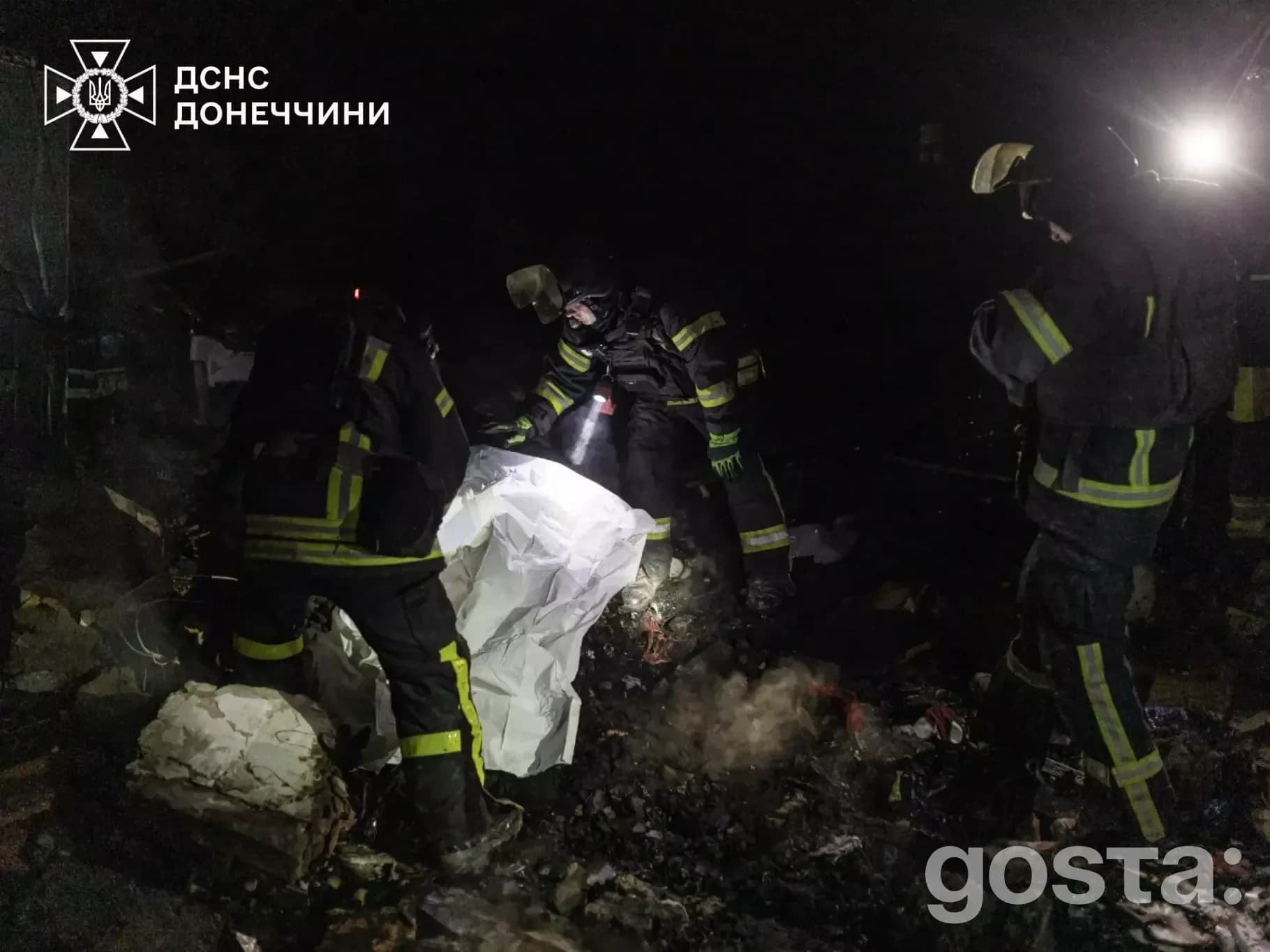Рятувальники ДСНС у темряві оглядають місце обстрілу, уламки та завали, працюють під потужними ліхтарями.