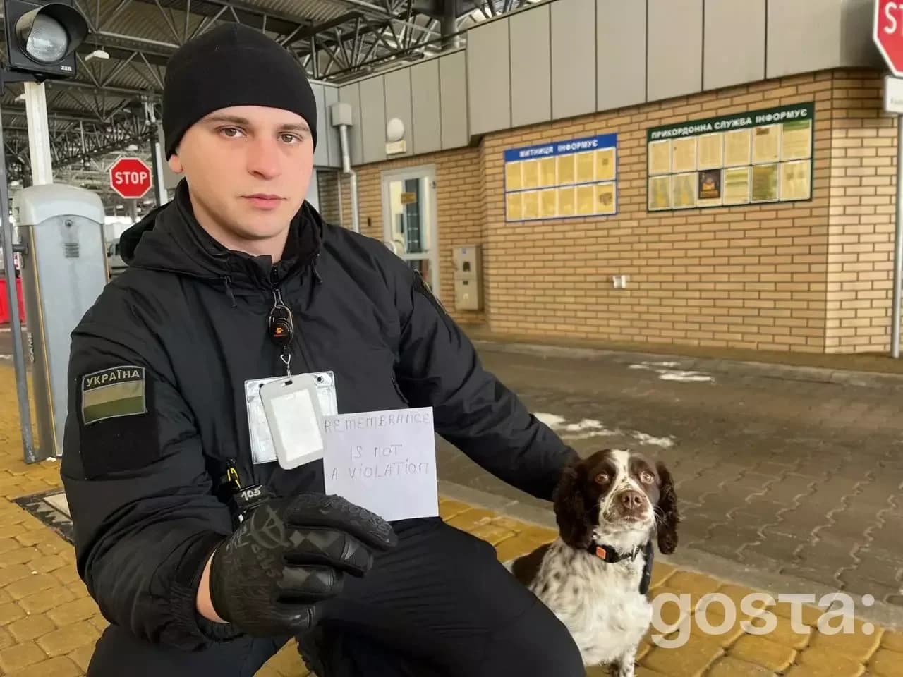 Особа у формі з прикордонним собакою тримає табличку з написом "Пам'ять – це не порушення".