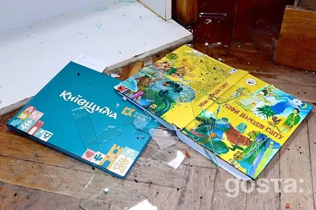 Пошкоджені дитячі книжки на підлозі серед уламків скла в Національній бібліотеці України для дітей після обстрілу.