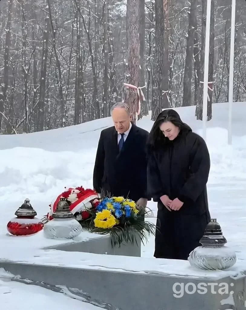 На фото Тетяна Бережна і Дональд Туск вшановують жертв репресій у Биківнянських могилах, Україна, сніжний пейзаж.